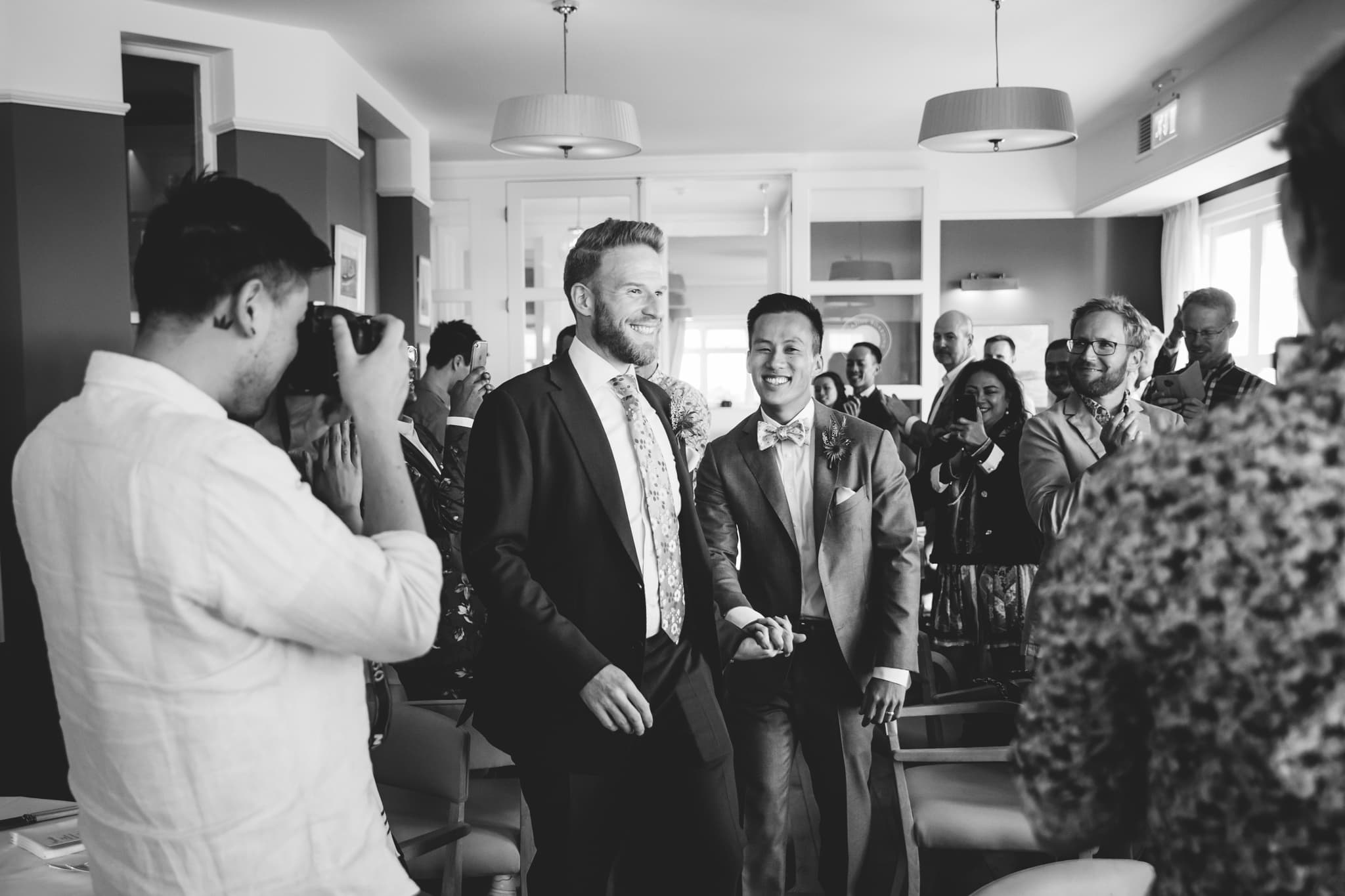 Same sex couple enter the wedding breakfast