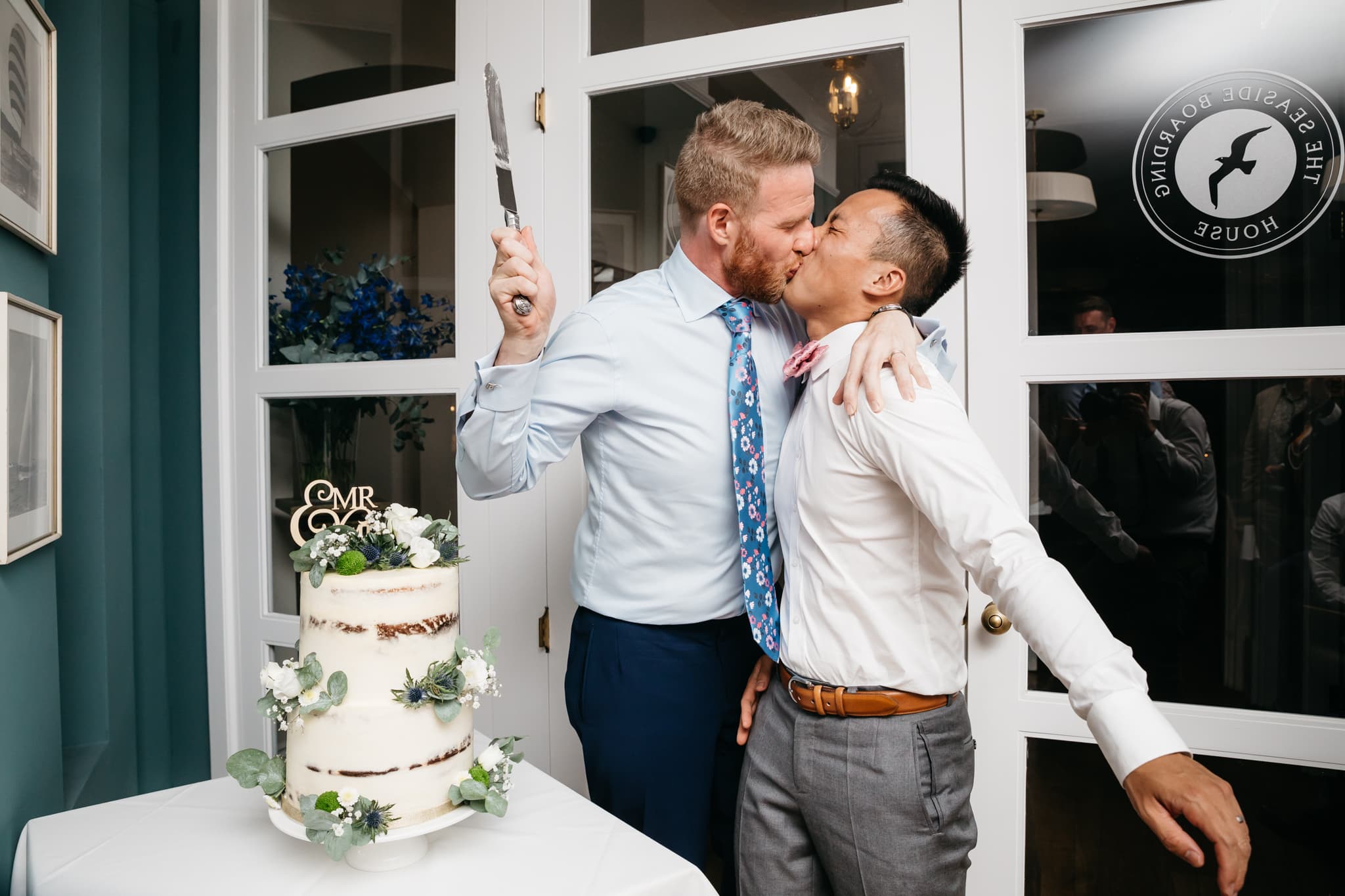 Same sex couple cutting their wedding cake